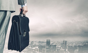 Man Overlooking City With Briefcase